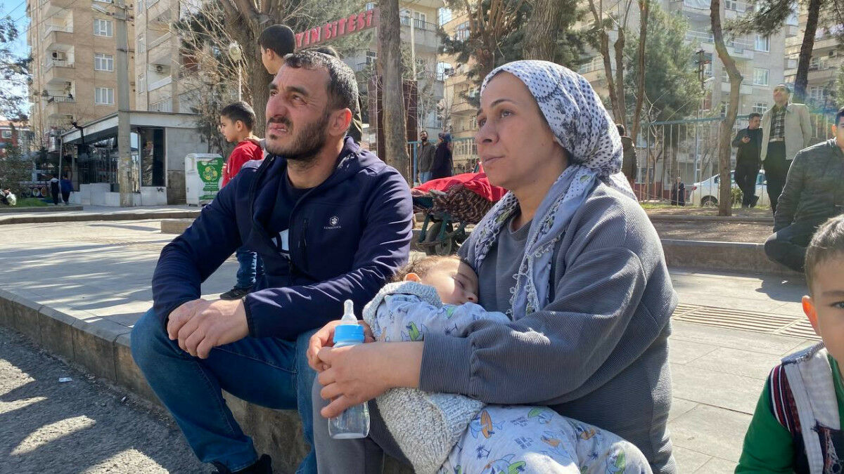 Depremin vurduğu Diyarbakır’da hasarlı evlerinden çıkan çift, binaya Türk bayrağı astı